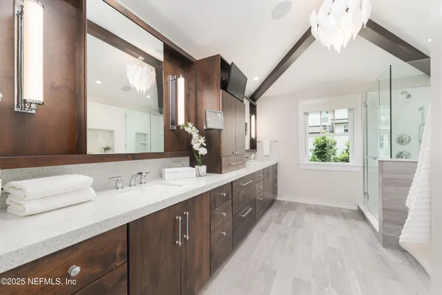 a spacious bathroom with a granite countertop sink mirror and a shower