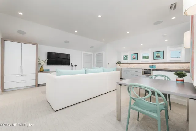 a living room with furniture and kitchen view