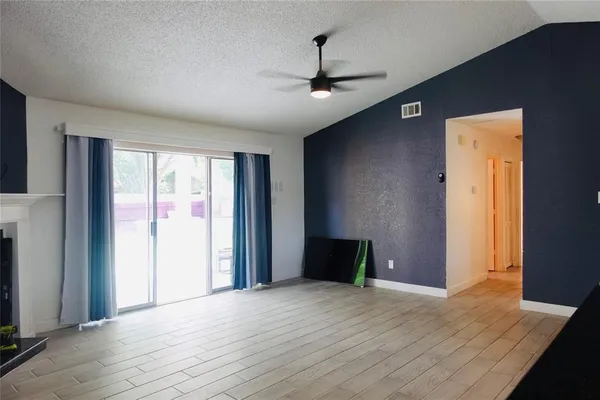 a view of empty room with wooden floor