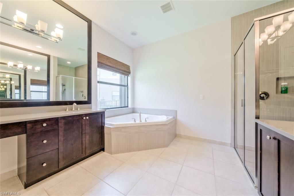 Undisclosed Address Naples, FL 34119 - Photo 20 of 32 a spacious bathroom with a tub sink and mirror