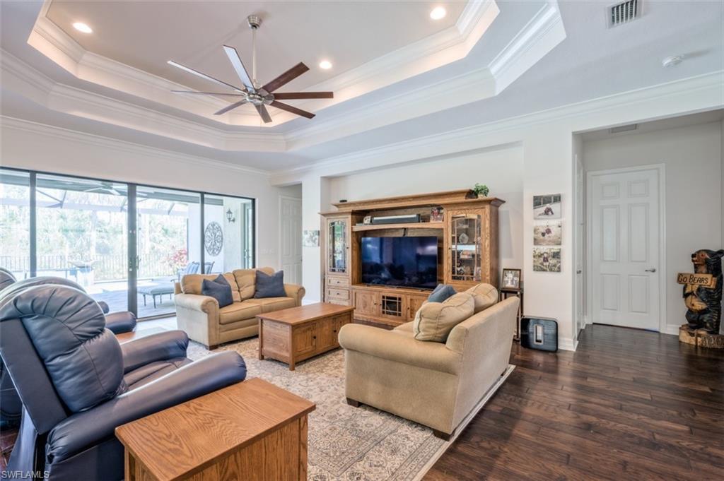 Undisclosed Address Naples, FL 34119 - Photo 6 of 32 a living room with furniture a ceiling fan a fireplace and a large window
