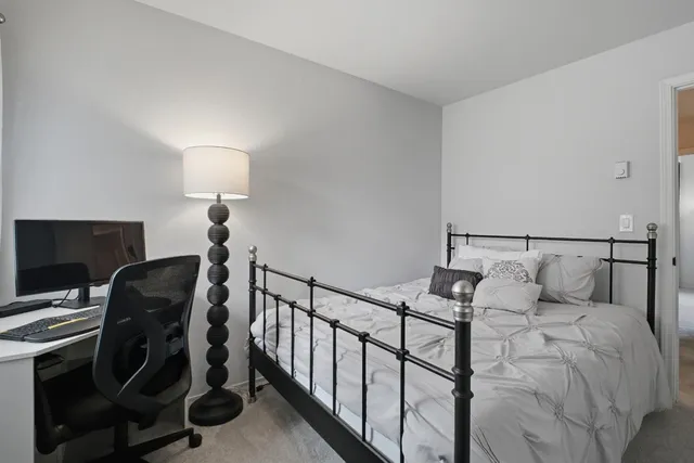 a bedroom with a bed and a desk