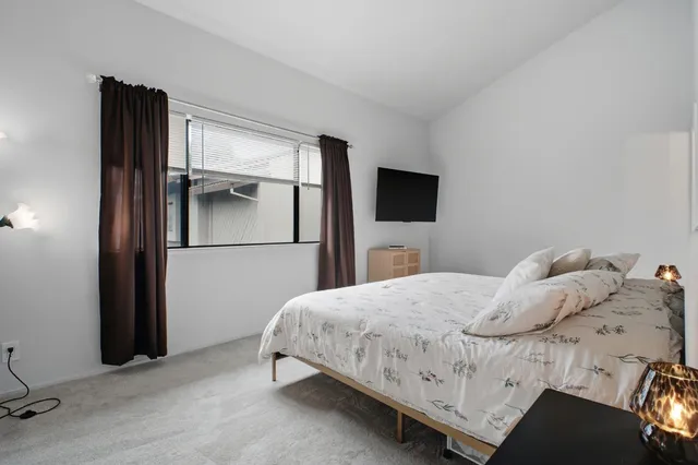 a bedroom with a bed and a large mirror