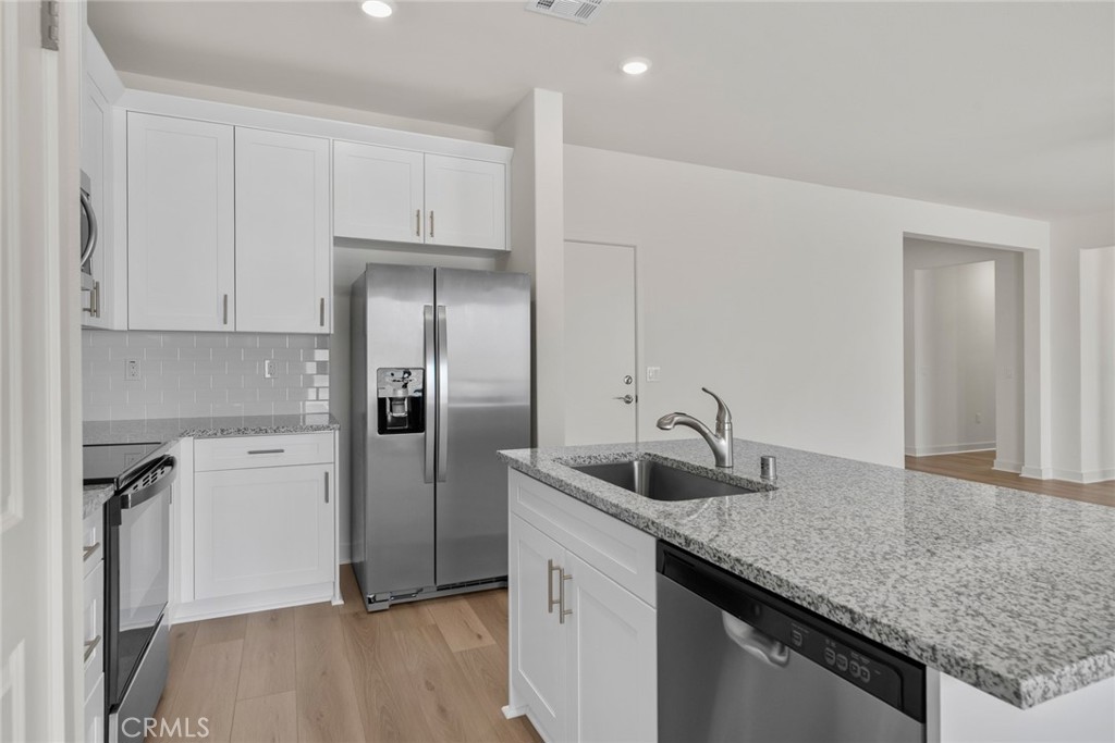14812 Indigo Street Apple Valley, CA 92307 - Photo 2 of 7 a kitchen with a sink a refrigerator and cabinets