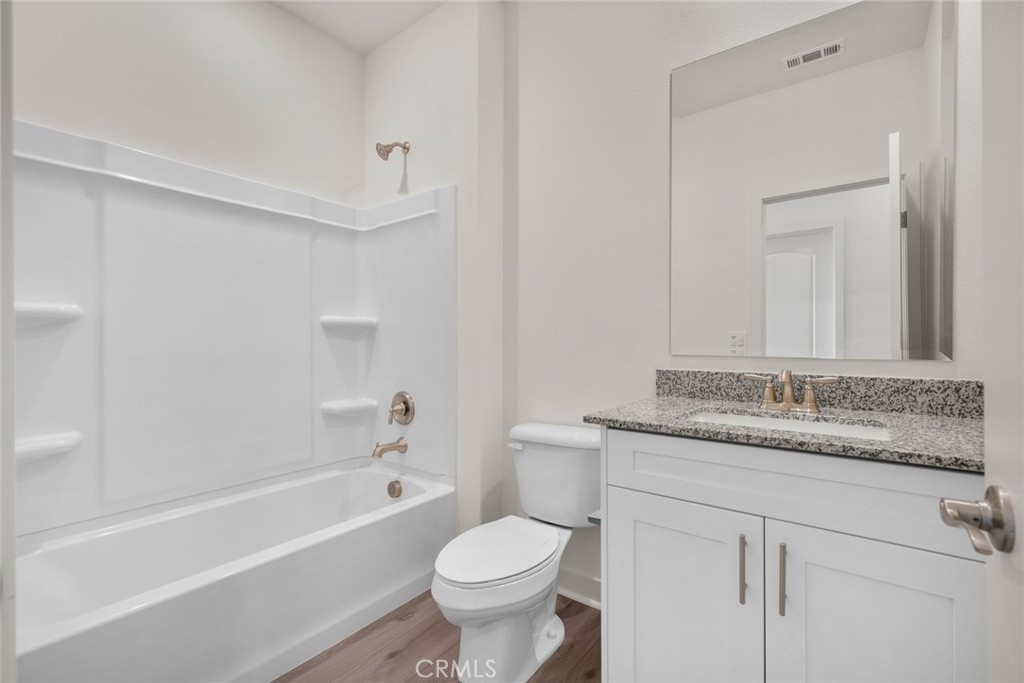 14812 Indigo Street Apple Valley, CA 92307 - Photo 6 of 7 a bathroom with a granite countertop toilet sink and mirror