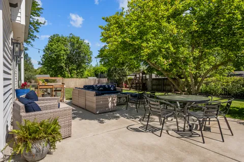 a view of backyard with outdoor seating a patio and plants