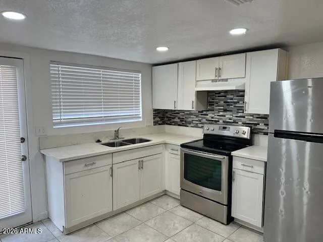 a kitchen with white cabinets and white appliances