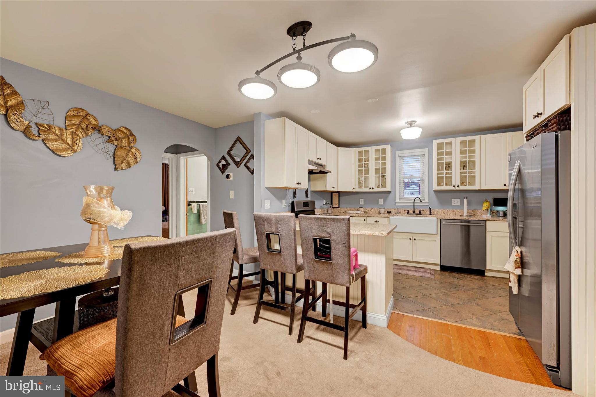 1813 Hanford Road Rosedale, MD 21237 - Photo 7 of 39 a kitchen with refrigerator a sink and chairs