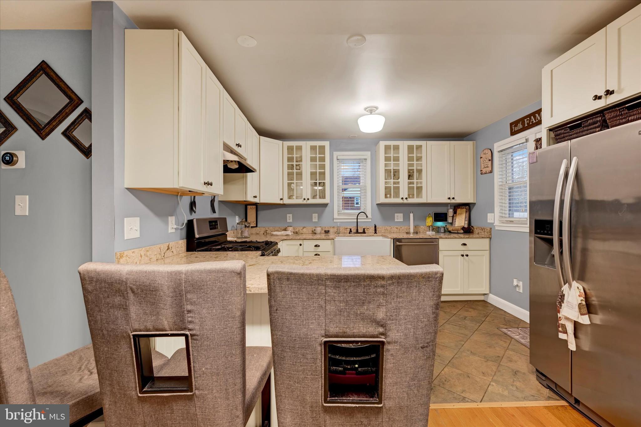 1813 Hanford Road Rosedale, MD 21237 - Photo 8 of 39 a kitchen with kitchen island a stove a refrigerator and a sink with wooden floor