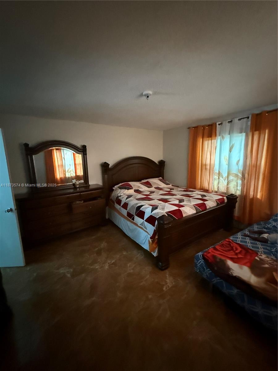 769 Southwest 8th Terrace Florida City, FL 33034 - Photo 12 of 25 a bedroom with a bed and a lamp on dresser