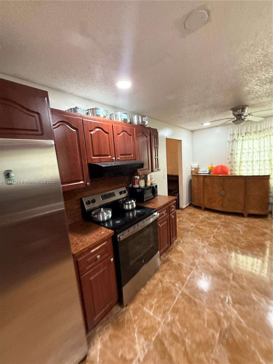 769 Southwest 8th Terrace Florida City, FL 33034 - Photo 14 of 25 a kitchen with stainless steel appliances granite countertop a stove a sink and a refrigerator