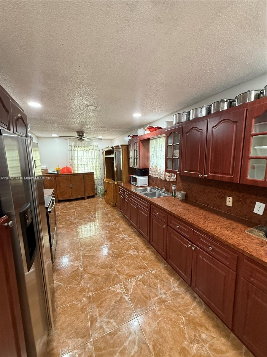 769 Southwest 8th Terrace Florida City, FL 33034 - Photo 18 of 25 a large kitchen with stainless steel appliances wooden cabinets a refrigerator and a sink