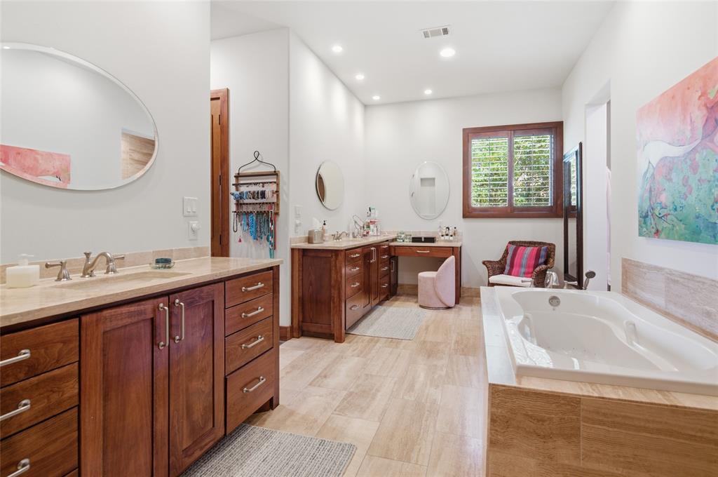 1138 Bancroft Road Keller, TX 76248 - Photo 19 of 39 Spacious bathroom featuring a built-in soaking tub, dual vanity with wood cabinetry and light-toned countertops, and wood-finish flooring