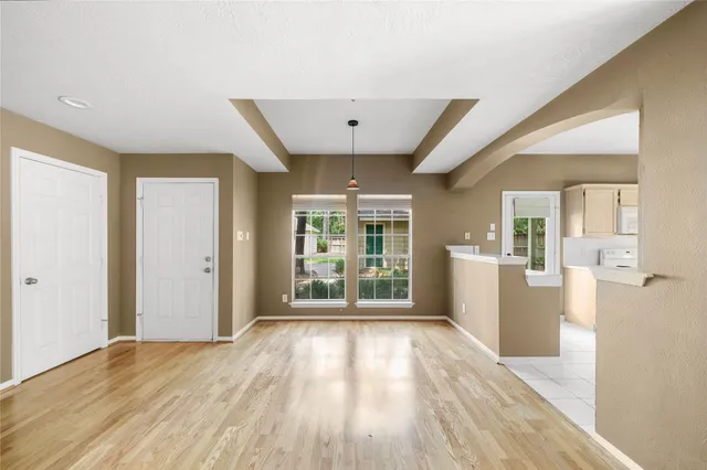 a view of a big room with wooden floor and windows