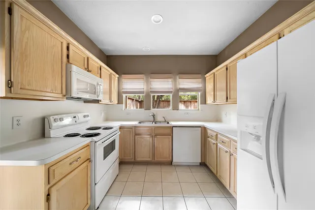 a kitchen with a stove sink and cabinets