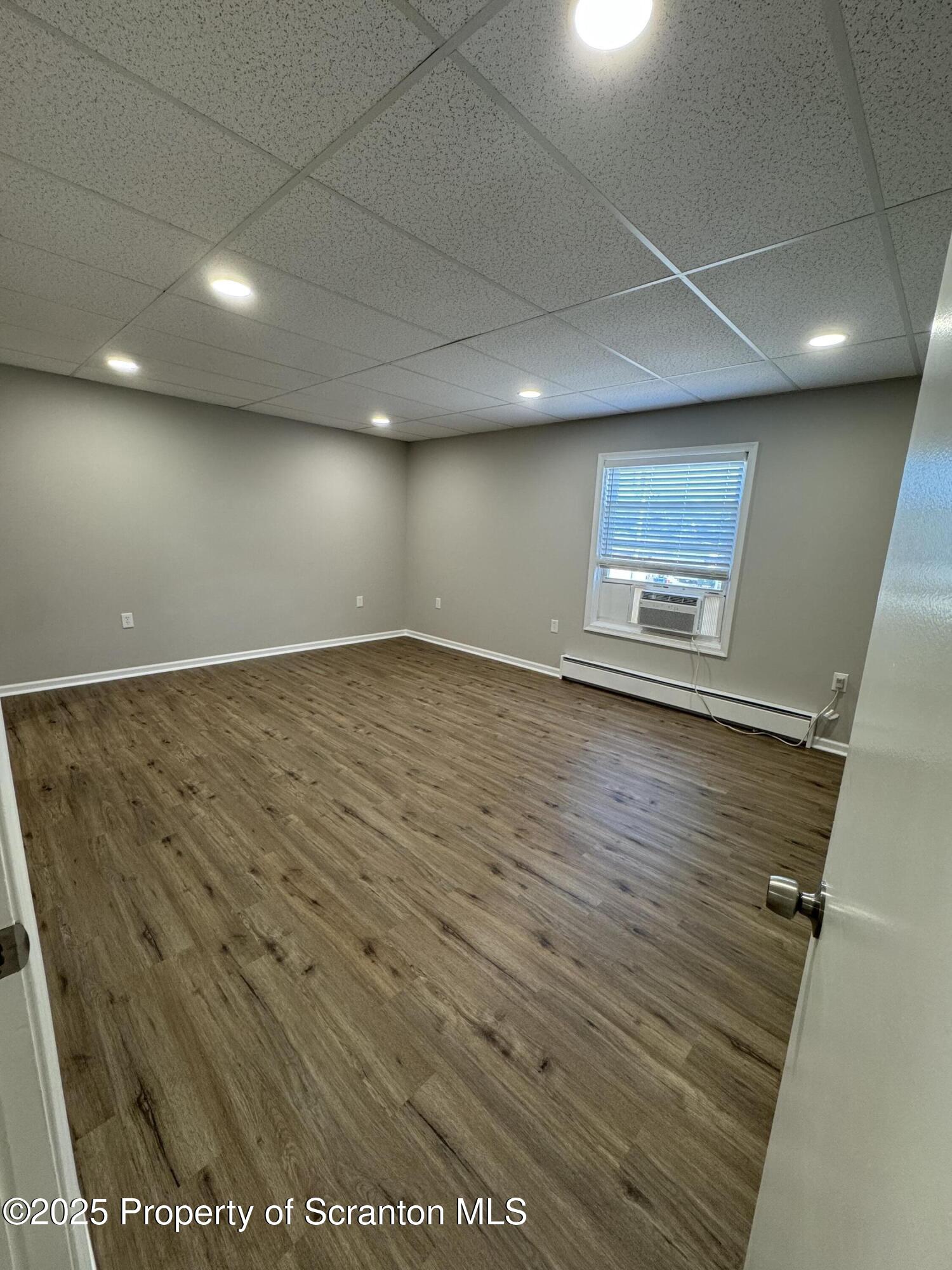 4 Kelly Street, Unit 8 Archbald, PA 18403 - Photo 11 of 16 an empty room with wooden floor and windows