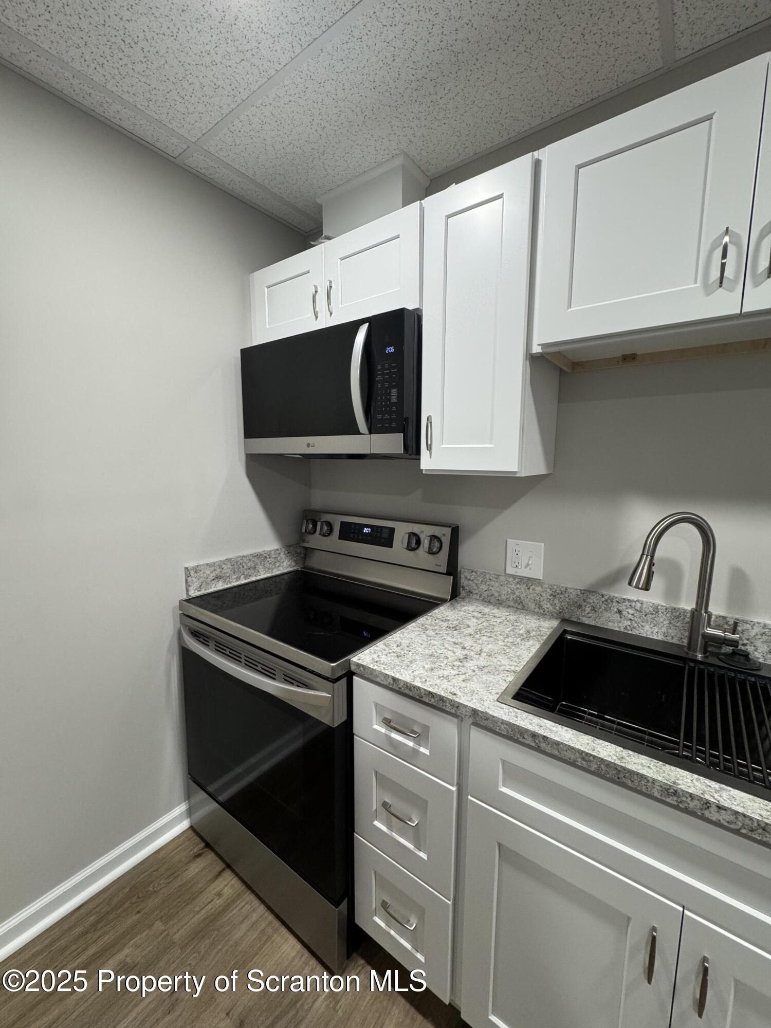 4 Kelly Street, Unit 8 Archbald, PA 18403 - Photo 4 of 16 a kitchen with stainless steel appliances granite countertop a sink stove and microwave