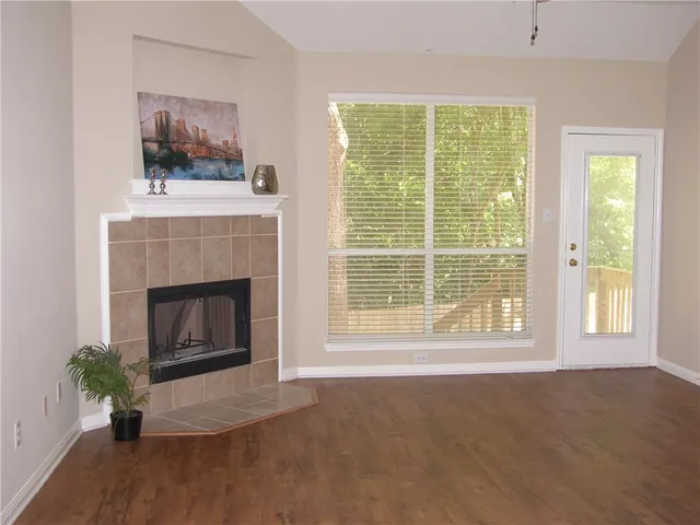a living room with a fireplace and a floor to ceiling window