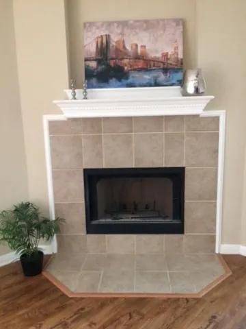 a living room with a fireplace and potted plant on counter