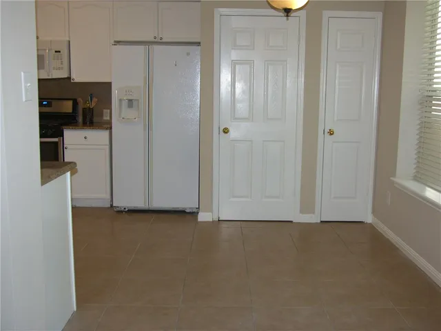 a view of kitchen with refrigerator and window