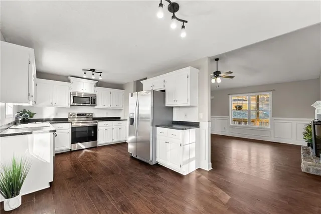 a kitchen with granite countertop white cabinets and stainless steel appliances