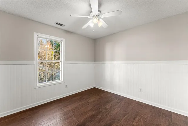 an empty room with a window and a ceiling fan