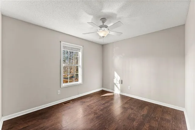 a bathroom with a granite countertop sink a toilet a mirror and shower