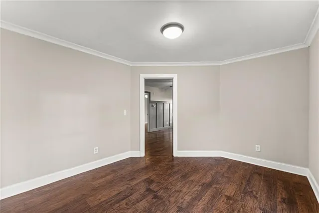 an empty room with wooden floor and closet