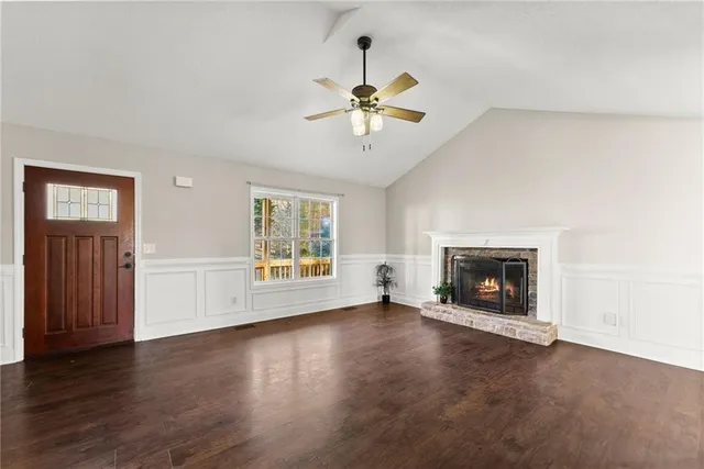 an empty room with windows and fireplace