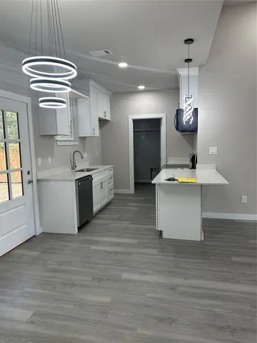 a large kitchen with a stove a refrigerator a sink dishwasher with a dining table and chairs