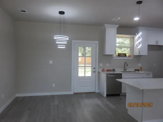 a kitchen with kitchen island granite countertop stainless steel appliances sink stove and cabinets