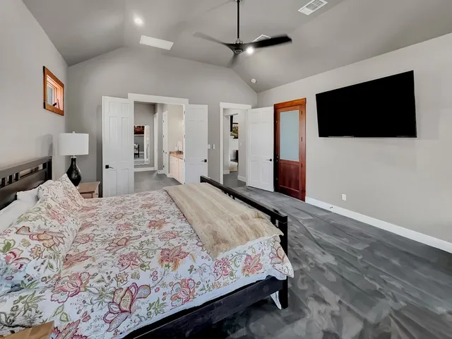 a bedroom with a bed window and a flat screen tv