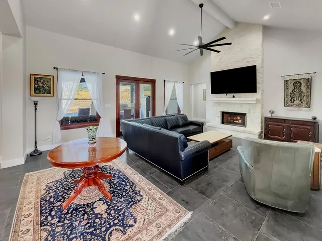 a living room with furniture a flat screen tv and a fireplace