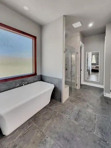 a spacious bathroom with a tub and a shower