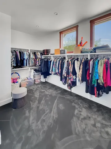 a view of a living room with clothes hanging and white walls