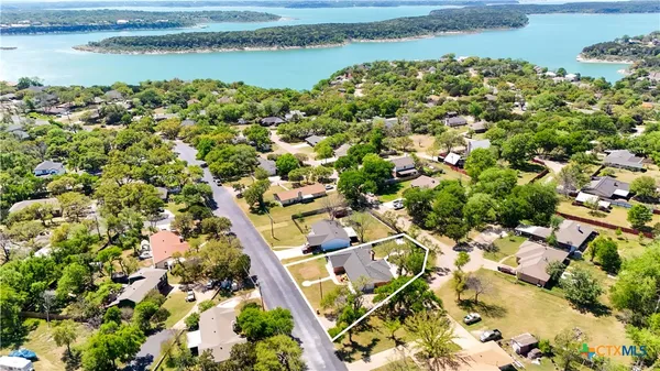 an aerial view of residential houses with outdoor space and lake view