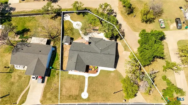 an aerial view of a residential houses with yard