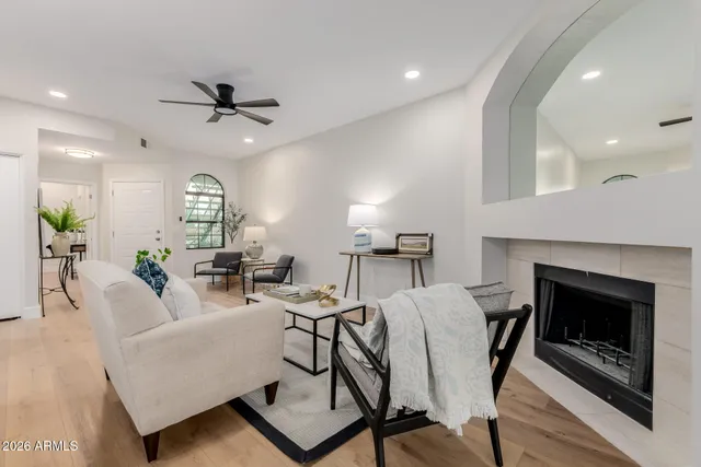 a living room with furniture a fireplace and a ceiling fan