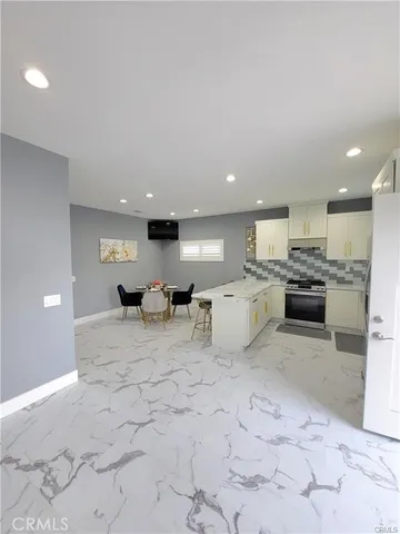 a view of kitchen with kitchen island microwave and cabinets