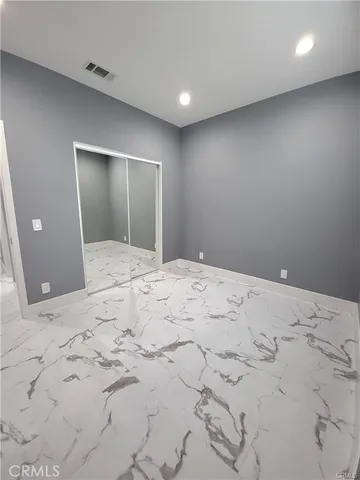 a view of a big room with wooden cabinet and mirror