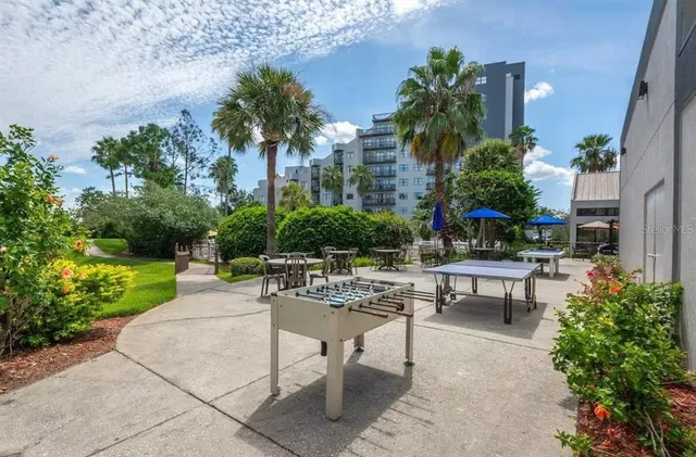 a view of a patio with couches and table and chairs with plants and trees