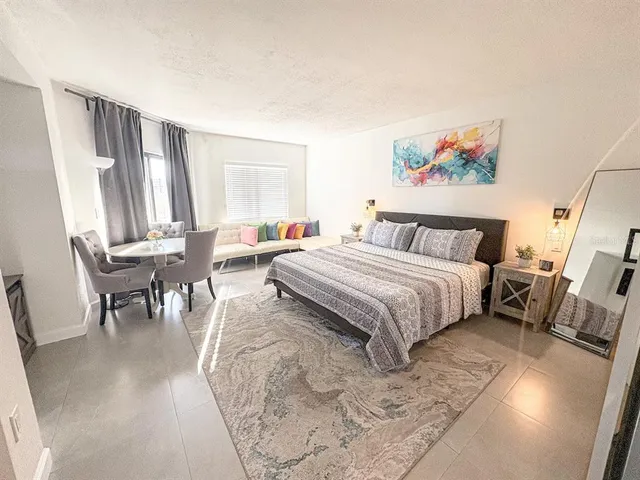 a spacious bedroom with a bed a couch and a window