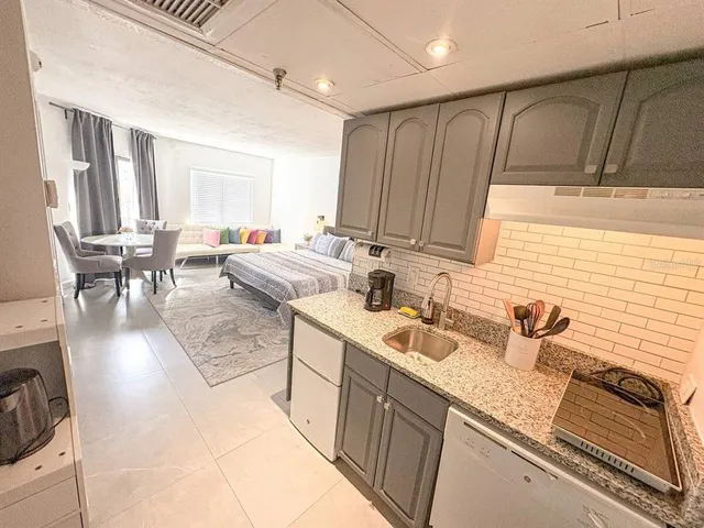 a kitchen with stainless steel appliances granite countertop a sink dishwasher stove and cabinets