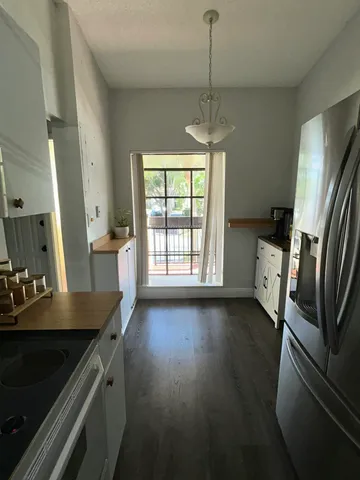 a kitchen with stainless steel appliances wooden floor and a refrigerator