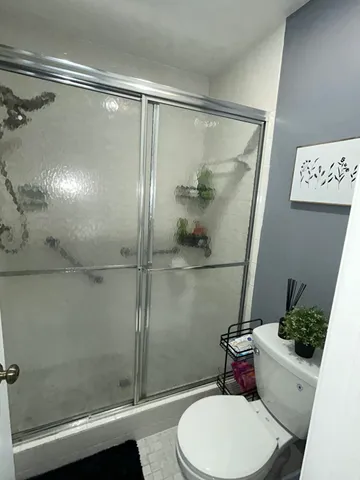 a bathroom with a toilet and a shower