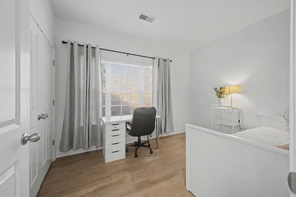 a view of a workspace with furniture and a window