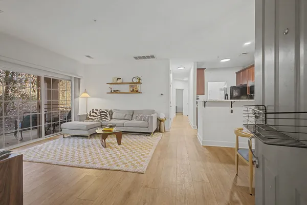 a living room with furniture wooden floor and a large window