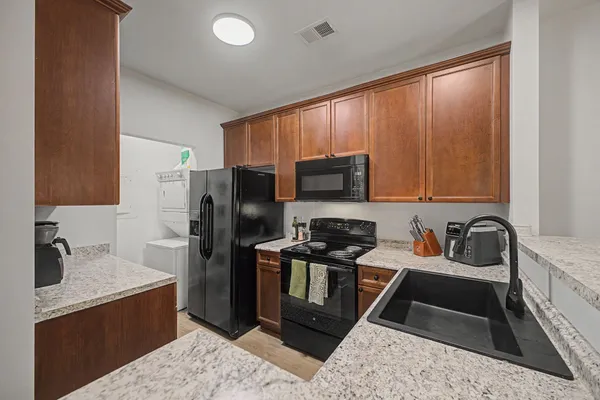 a kitchen with stainless steel appliances granite countertop a sink stove and refrigerator