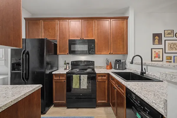 a kitchen with granite countertop a refrigerator stove and sink