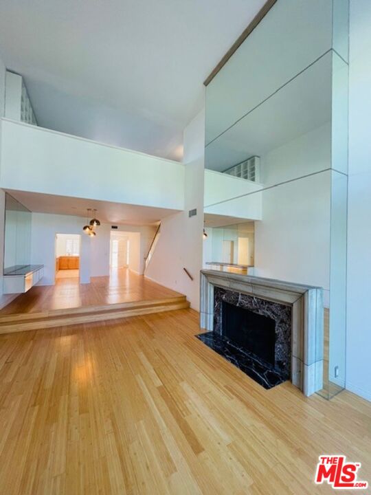 a view of a livingroom with wooden floor and a fireplace